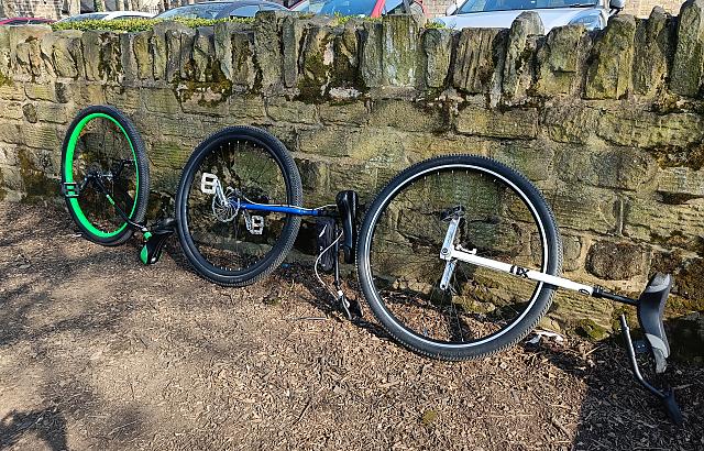 Three 36" unicycles resting against a wall