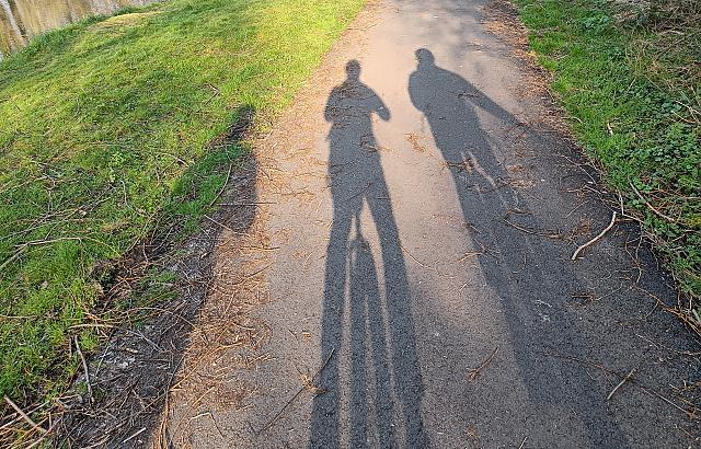 Shadows of three people riding unicycles
