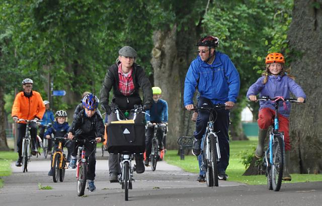 Cyclists of many ages riding through Dock Park. 