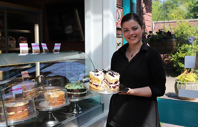 Abbie from the Walled Garden Cafe holds a cake. 