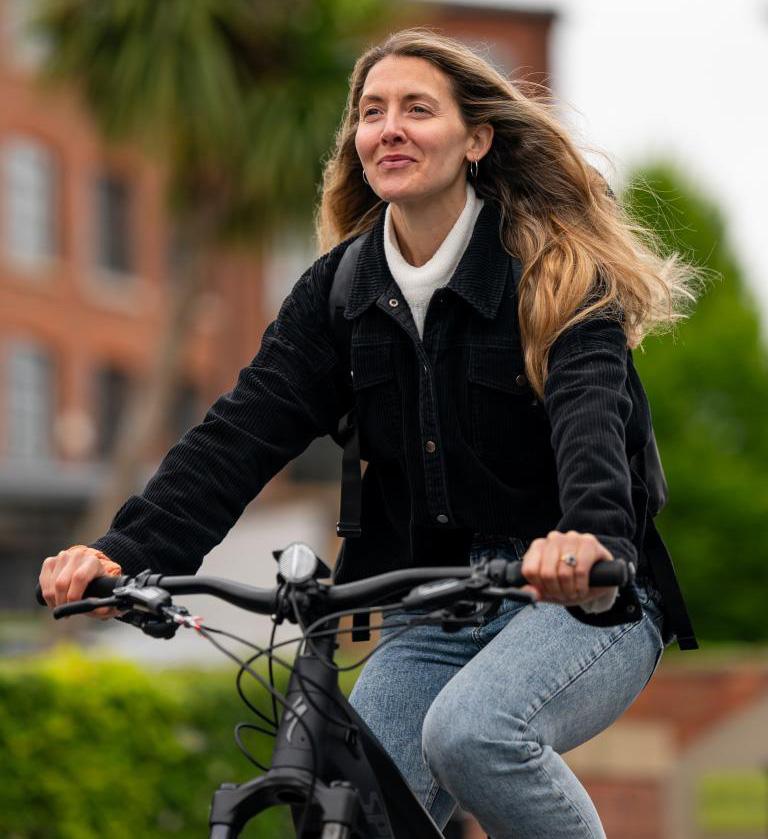 A woman cycling on a Tier eBike. 