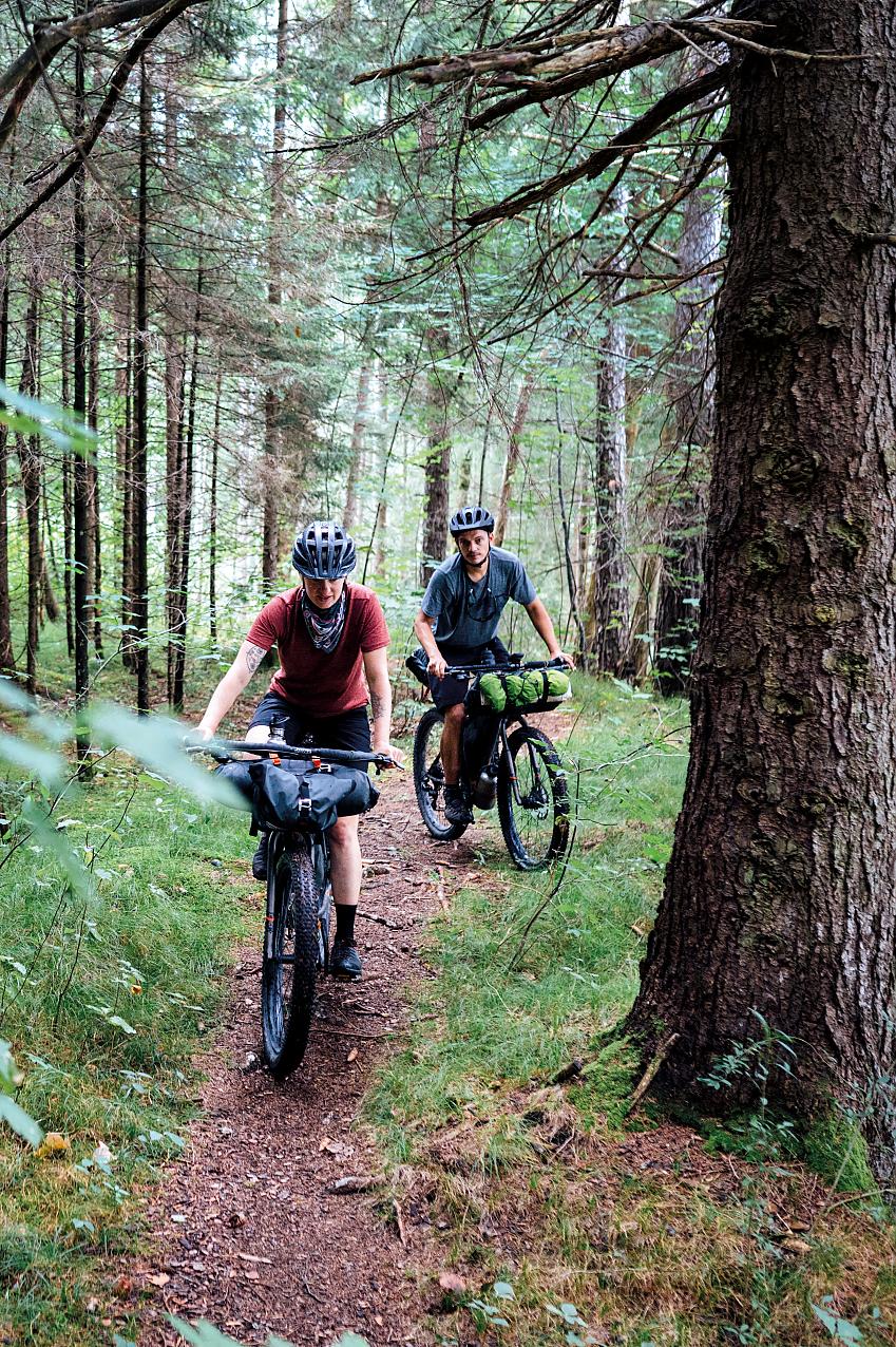 Two cyclists riding with bikepacking bags