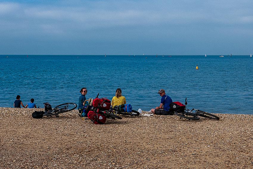 Three cyclists enjoy a picnic on Whitstable Bay's cobbled beach