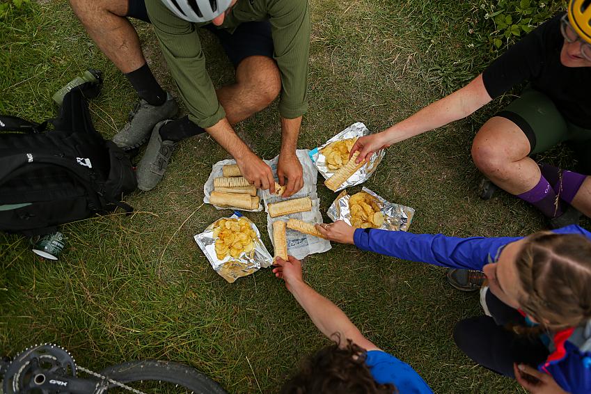 Cyclists share a healthy lunch of baked goods and crisps