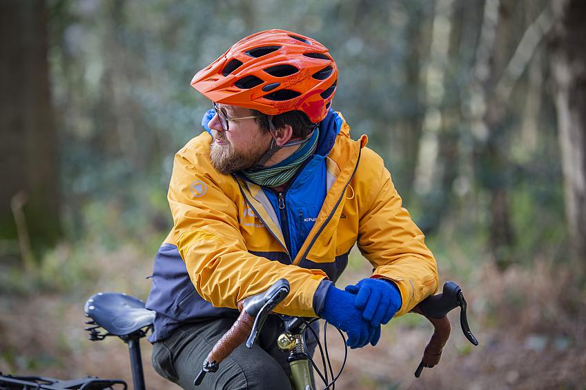 A man on a bike showing his merino neckwarmer to stay warm