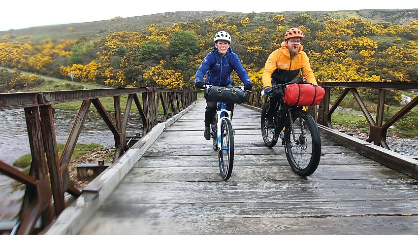 Two riders rumbling over the wooden bridge on the way back from Cape Wrath