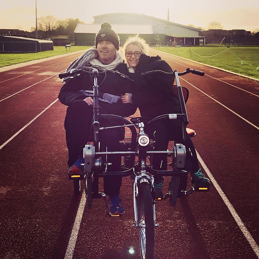 Colin with his partner Holly, using an adapted cycle. Colin's injuries mean he's no longer able to cycle unassisted. 2019