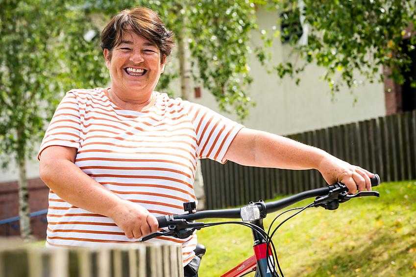 A smiling woman posing with her new bike