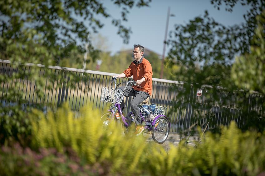 A man riding an e-trike in an urban environment