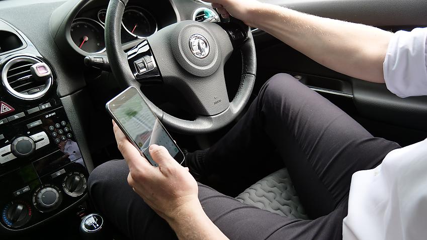 Person using phone behind the wheel
