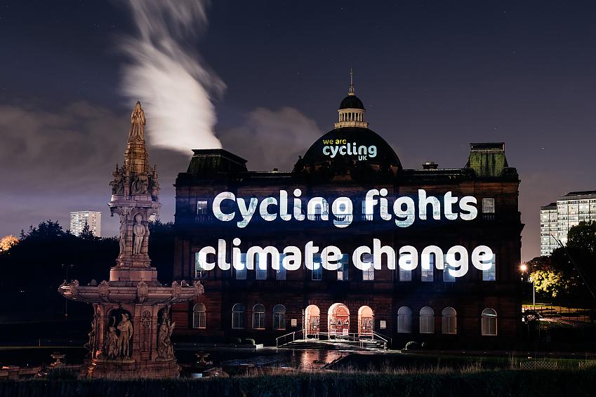 Projection saying 'cycling fights climate change'