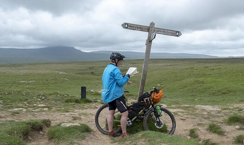 Woman with mountain bike looking at a map