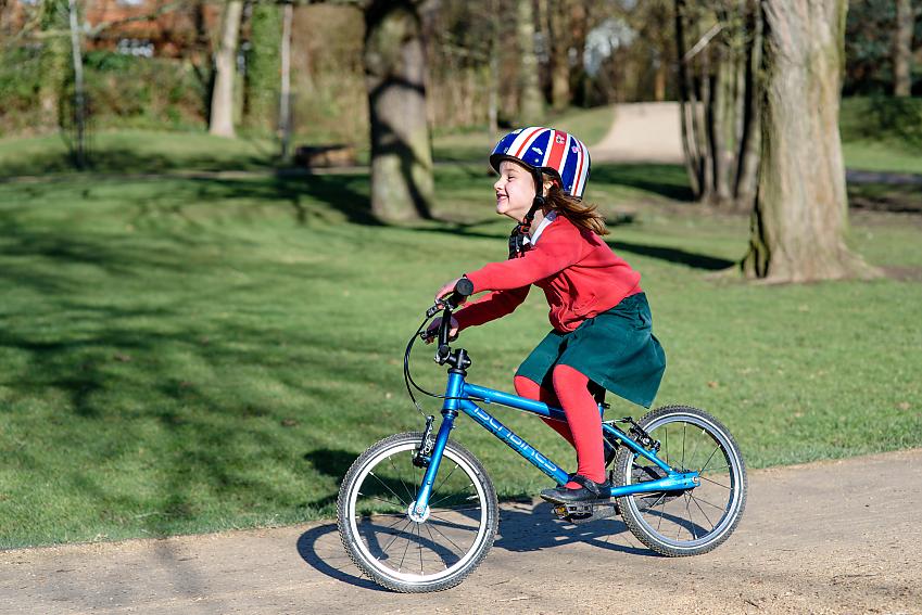 Girl smiling cycling through park