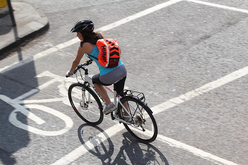 Woman cycling at a city junction