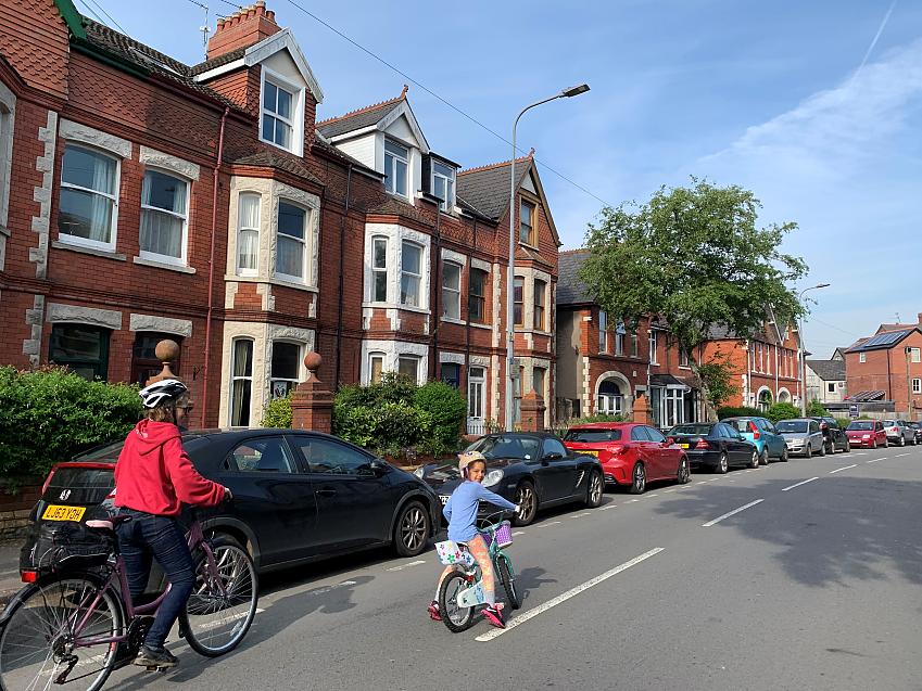 Woman and young child cycling along a quiet residential street