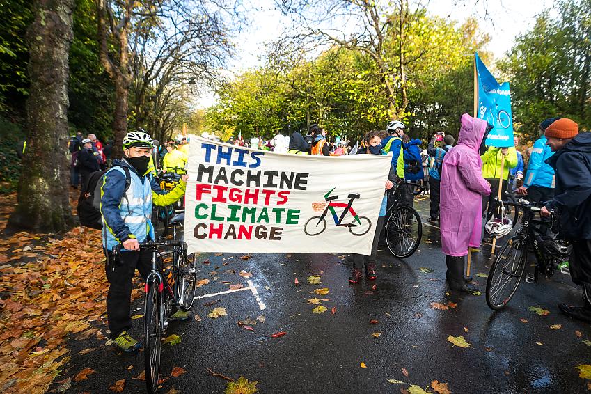 Cyclists with banner that says "This machine fights climate change"