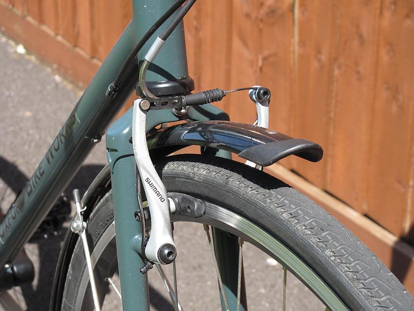 A close-up showing the Model 1E's brakes and front fork