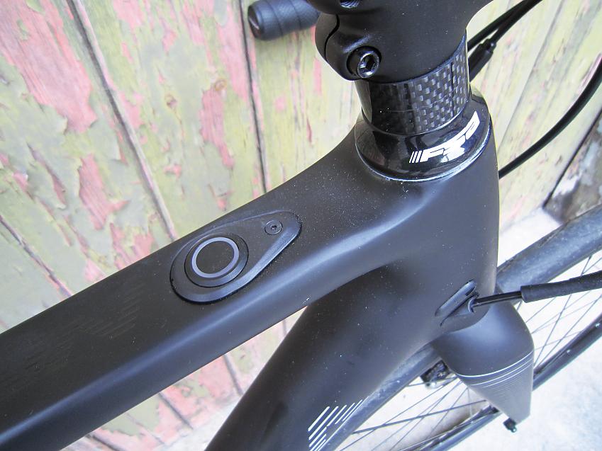 A close-up of the Orbea's top tube showing the on-off button