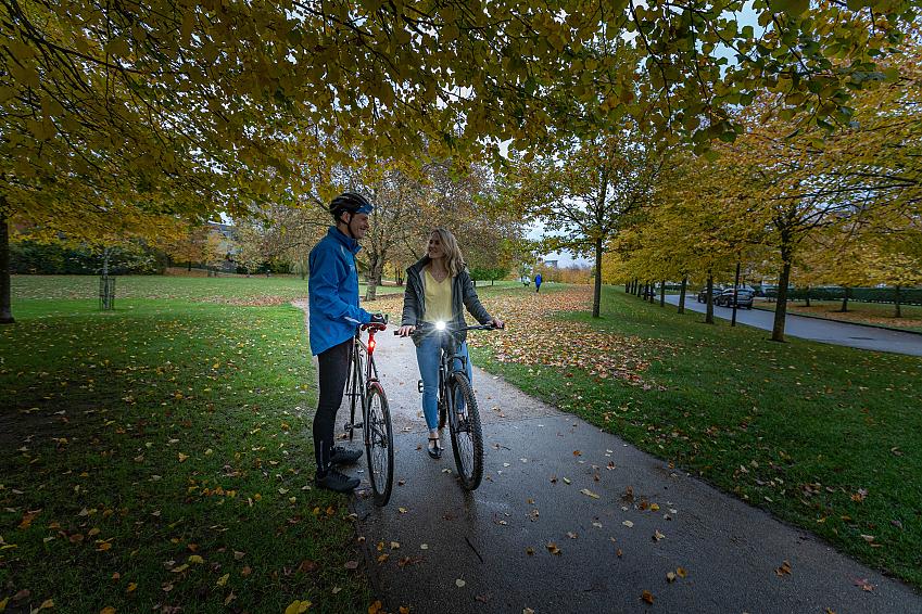 A woman and man with their bikes in a dusky park