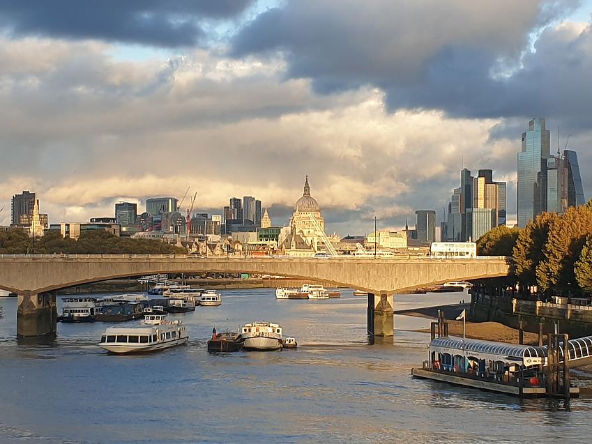 A shot of the Thames from a bridge, showing Waterloo Bridge, with St Paul's Cathedral and skyscrapers in the background