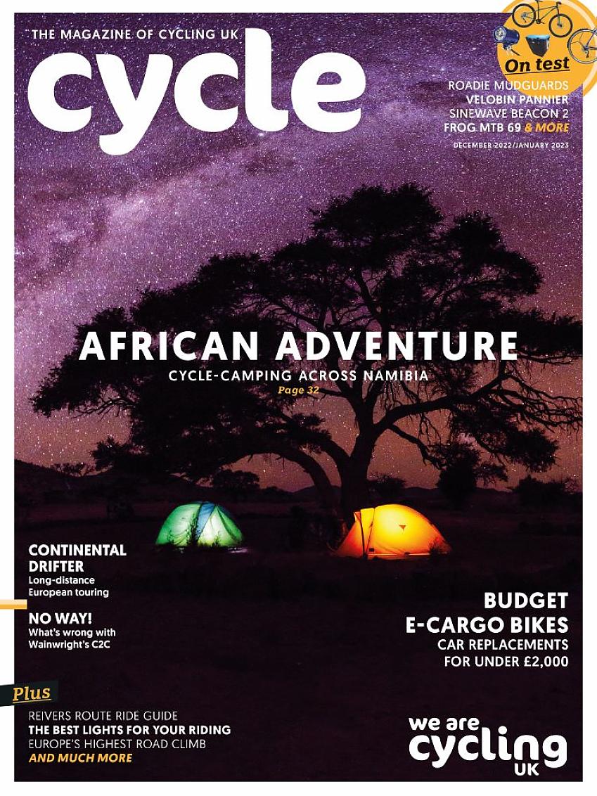 Cover of Cycle magazine Dec 22-Jan23 issue showing two tents in an African landscape. It's night time and the tents are lit up from the inside. A big tree is silhouetted against a starry sky
