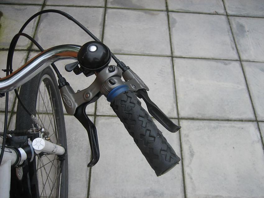 A close-up of a bike handle bar showing two brake levers on the same side