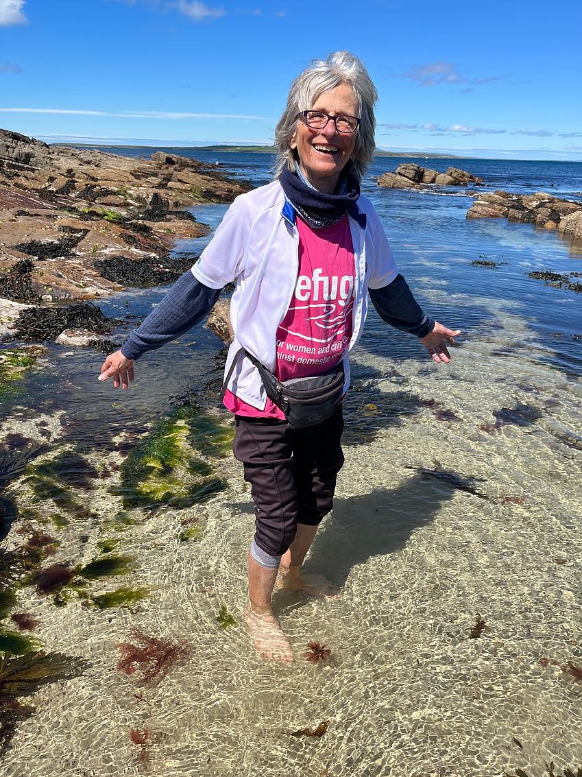 Cyclist Gina Harris paddling in the sea at Dunnet Head in northern Scotland