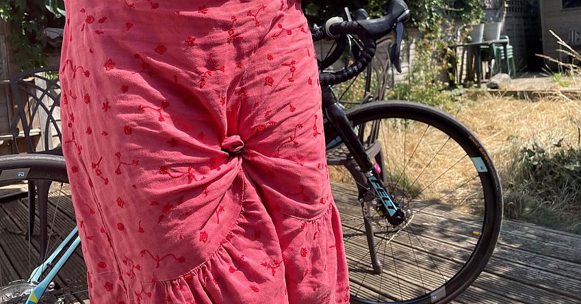 A woman in a dress demonstrating how Penny in Yo Pants transforms a skirt into culottes for cycling in
