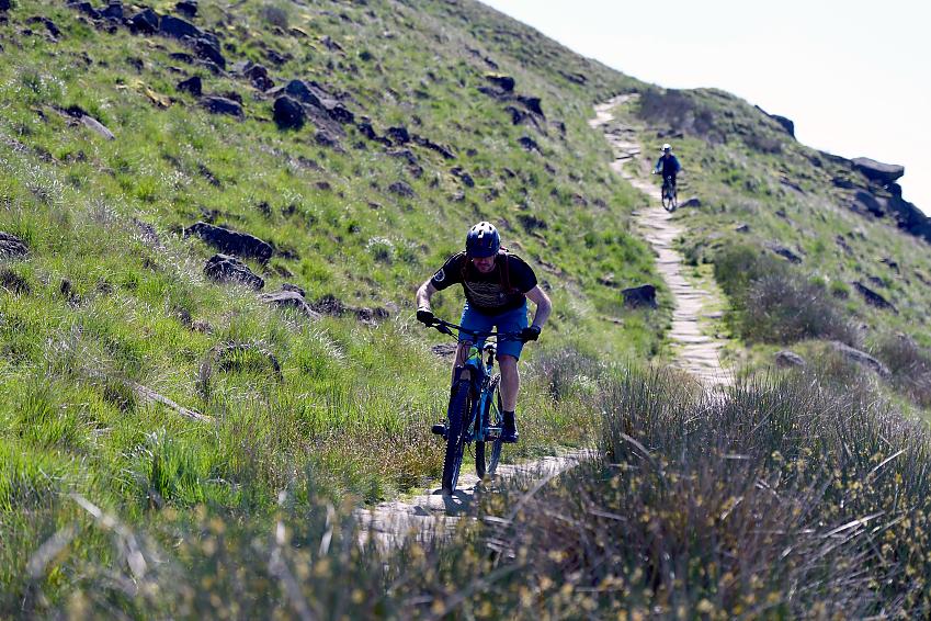 Mountain biker riding down a stone trail