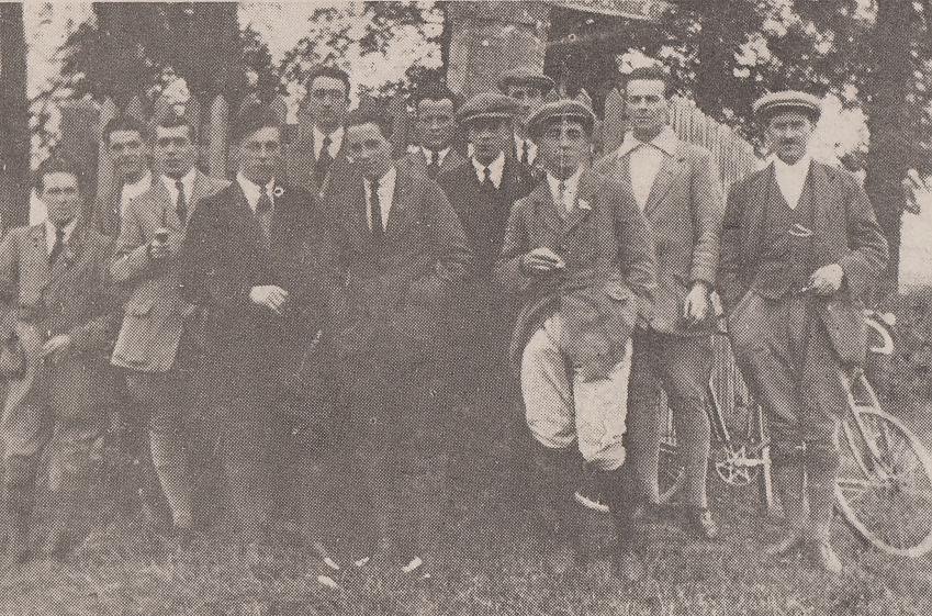 A black and white photo from 1921 showing a group of cyclists on the first club run. They're all men and all wearing jackets and ties and hats