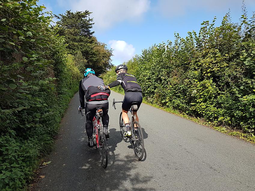 Cyclist getting a helping hand up the hill