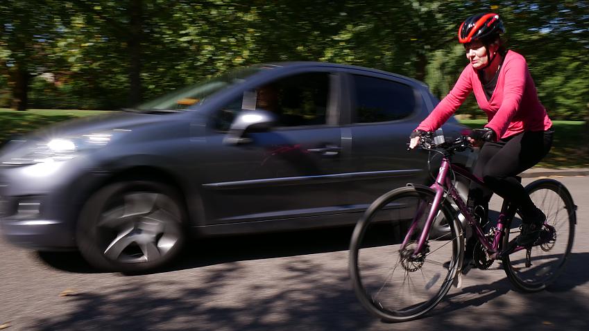 Car passing a cyclist at high speed