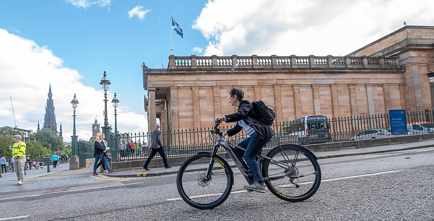 Woman cycling on a road in Edinburgh