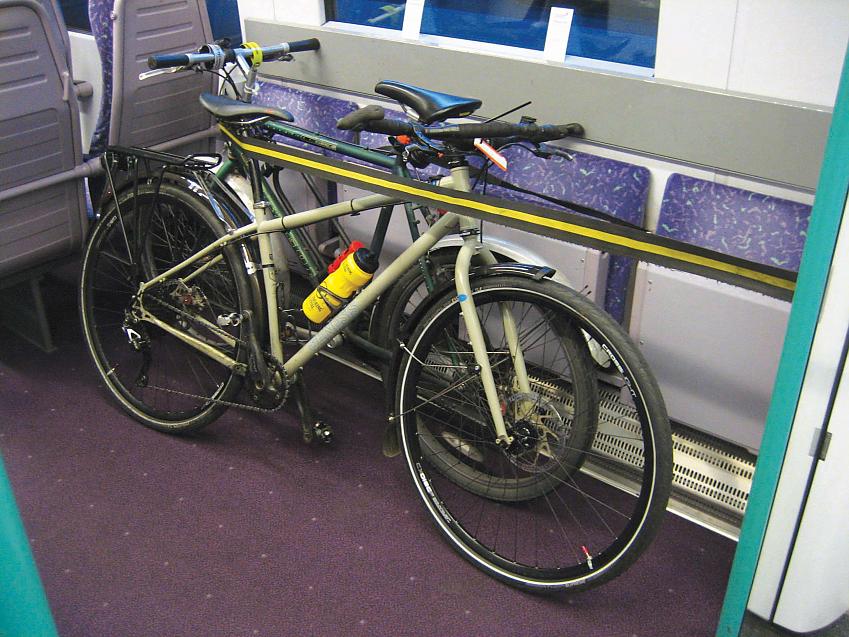 Two bikes are secured in the cycle area of a train
