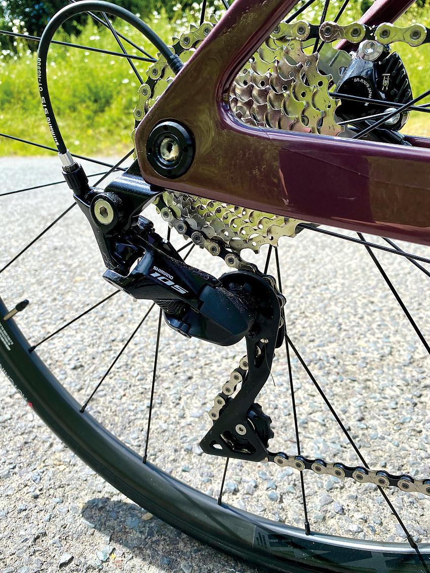 A close-up of the Van Rysel's cassette, also showing part of the purple chainstay and seatstay and rear derailleur