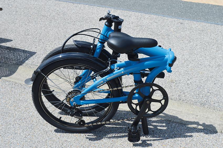 The Tern Link B7, a blue small-wheeled folding bike, fully folded down