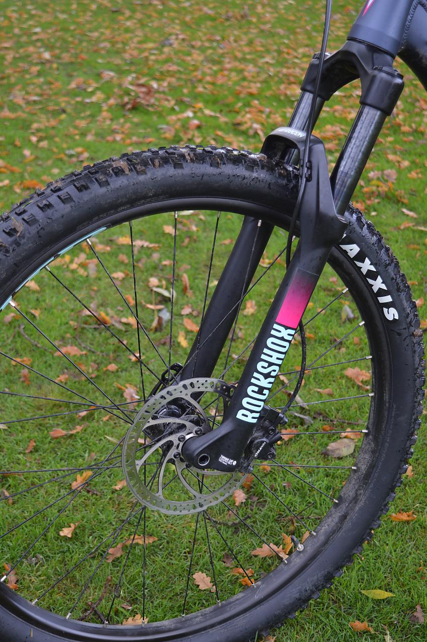 A shot showing the front wheel of a mountain bike, with disc brakes and suspension