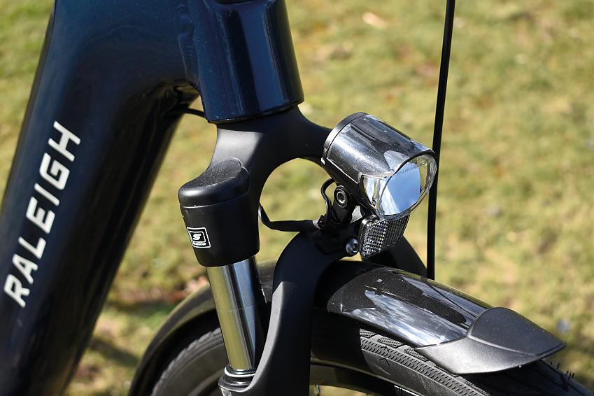 A close up of an e-bike's front light, fork and mudguard