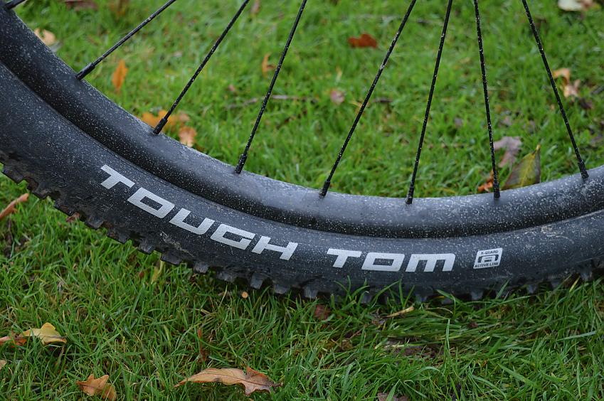 A close-up of a mountain bike wheel and tyre, showing the brand name, Tough Tom