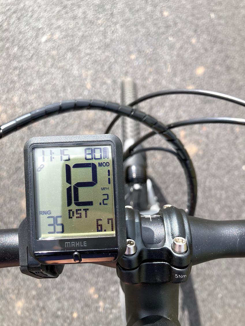 The digital display on an e-cycle mounted to its handlebar shows various data