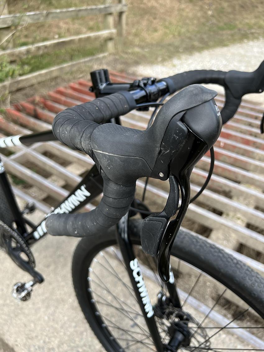 A close-up of the Schwinn's handlebar showing the brake lever and gear shifter