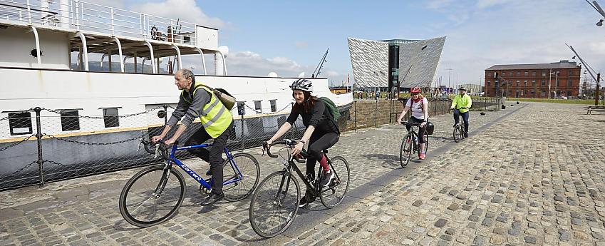Three cyclists on a dockfront