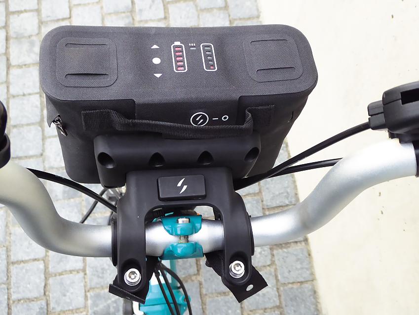 A close-up of the Swytch battery pack attached to a Brompton bike handlebar