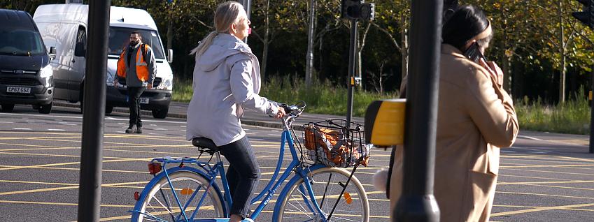 Woman riding a Dutch bicycle at a junction