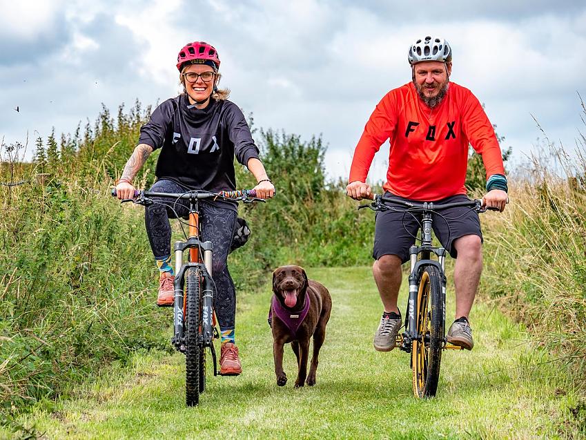 Cycling UK’s head of volunteering Alex Cuppleditch and her fiancé cycle with labrador George
