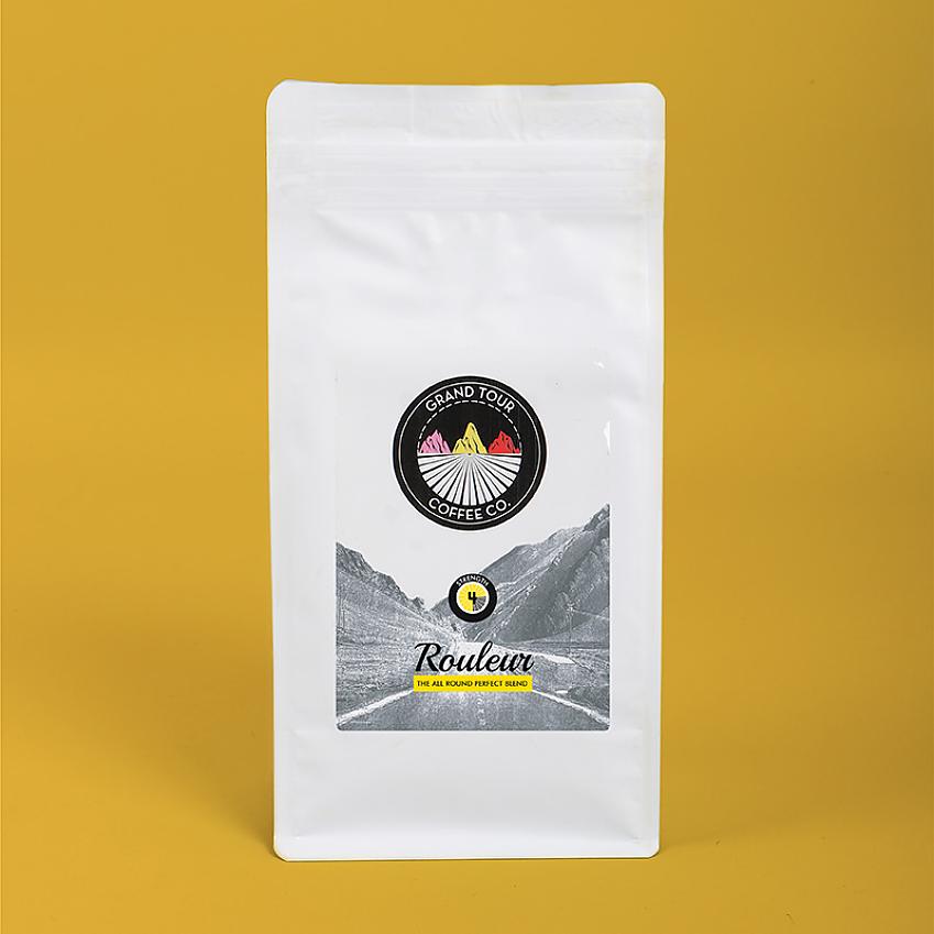 A white bag of coffee against a yellow background
