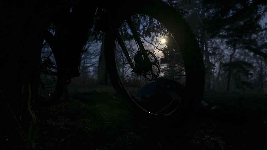 The full moon at dawn viewed through a bike wheel