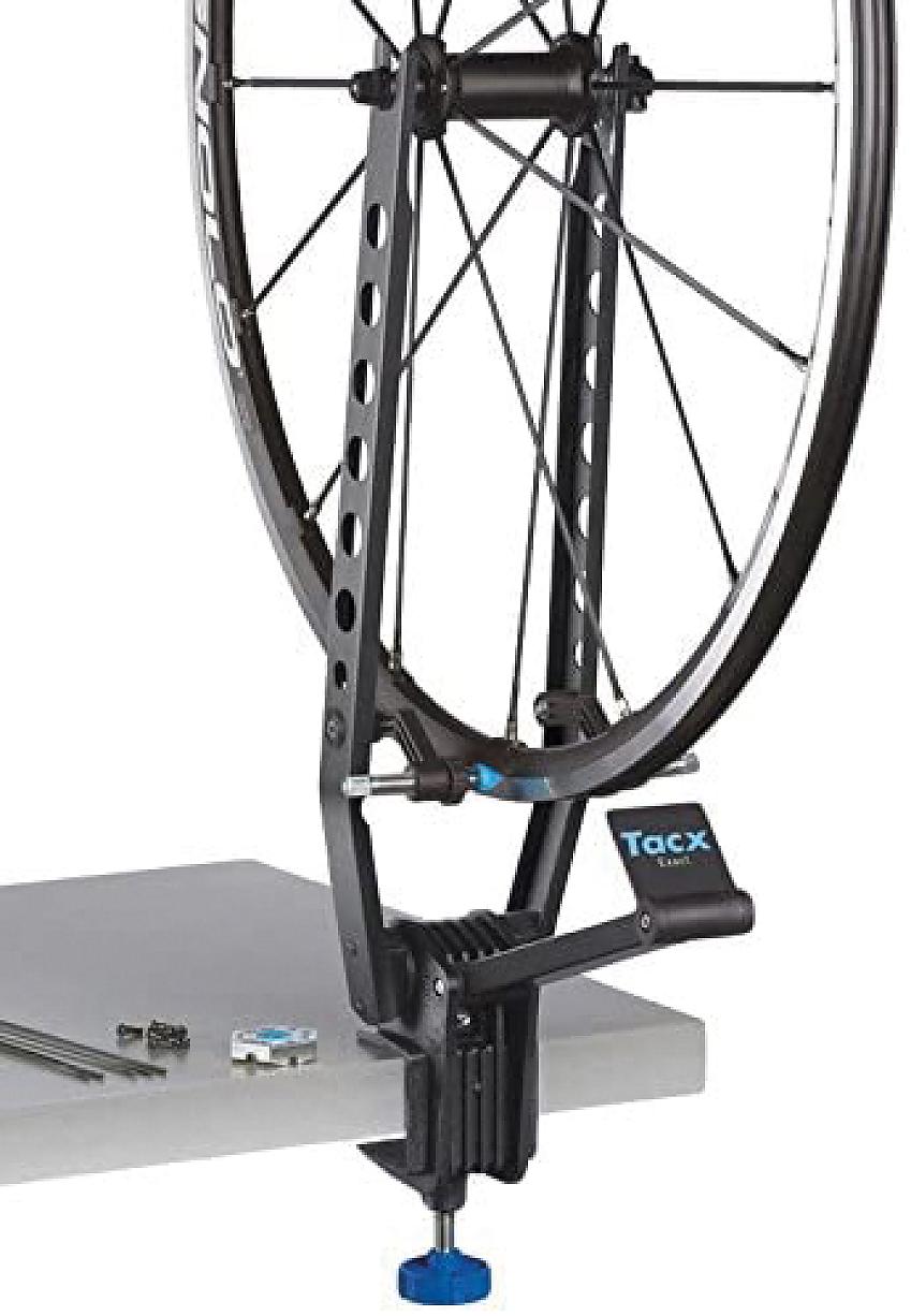 Tacx Exact Wheel Truing Stand in use, clamped to a bench and holding a bike wheel