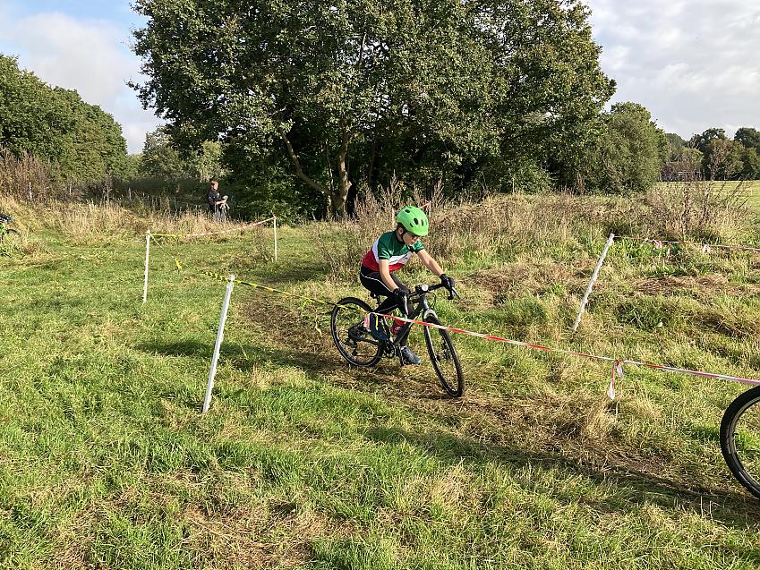 A young cyclist is taking part in a cyclocross race