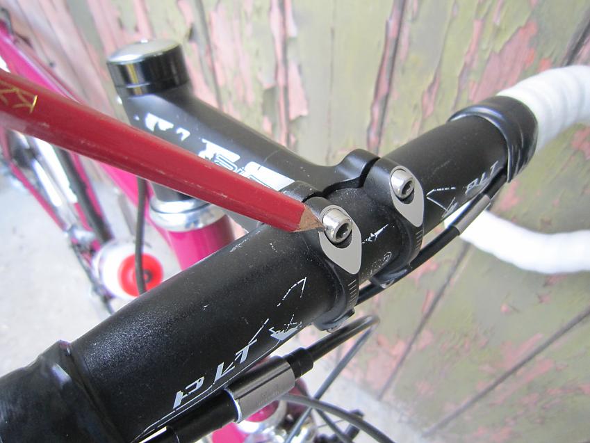 A close-up of bicycle handlebars showing the small fasteners